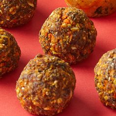 several balls of food sitting next to each other on a red tablecloth with oranges in the background