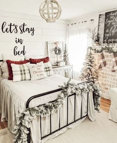 a bed room with a neatly made bed and christmas decorations on the wall above it