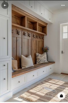 a wooden bench sitting in the middle of a room next to a white door and window