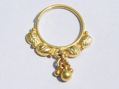 a gold colored metal ring with bells and leaves on the end, attached to a chain