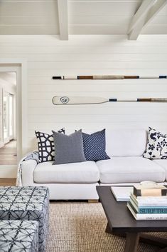 a living room filled with white furniture and lots of pillows