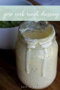 a jar filled with dressing sitting on top of a wooden table