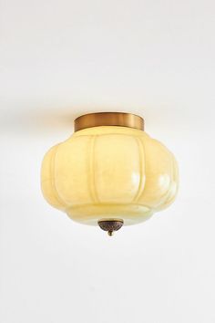 a white ceiling light with a yellow glass shade