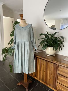 "ITEM OVERVIEW   Ethically handmade garment Fabric: plus size clothing, linen, dress, seaweed green gauze linen, long sleeves with shired cuff, scoop neckline with Peter Pan collar, smock style dress, women's fashion, Australian made. Delivers world wide from  Geelong, Victoria Australia  ITEM DETAILS Loose fit dress, made in a muted seaweed green coloured guaze linen fabric, has a scoop neckline with Peter Pan collar and  long sleeves and shiring at the wrist, allowing the sleeve to be pushed u Linen Smock Dress, Long Sleeve Linen Dress, Loose Fit Dress, Linen Gauze, Garment Fabric, Natural Fibre, Loose Fitting Dresses, Victoria Australia, Gathered Skirt