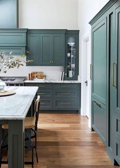 a kitchen with green cabinets and wooden floors