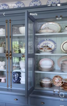 a blue china cabinet filled with lots of dishes