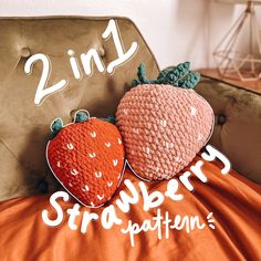 two knitted strawberries sitting on top of an orange blanket next to a brown chair