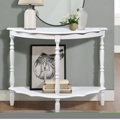 a white console table with a mirror and lamp