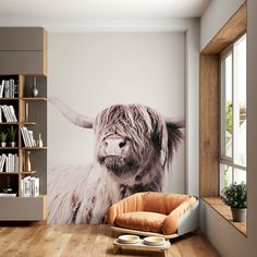 a living room with a cow mural on the wall and a chair in front of it