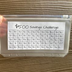 a person holding up a plastic box with a sign on it that says $ 500 savings challenge