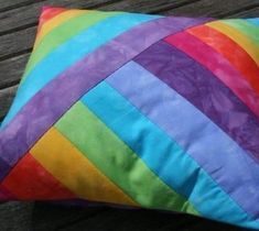 a colorful pillow sitting on top of a wooden bench