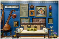 a living room with blue walls and lots of pictures on the wall, including a couch