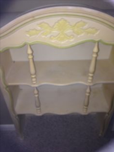 a white and green shelf sitting on top of a carpeted floor