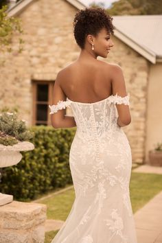 a woman in a wedding dress standing outside