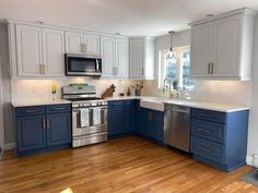 an empty kitchen with blue cabinets and stainless steel appliances