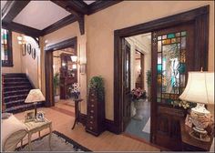 a living room filled with furniture and lots of woodwork on the walls, along with windows