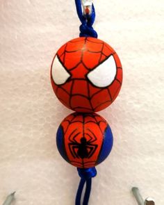 a spiderman ball hanging from a hook on a white wall with two screws