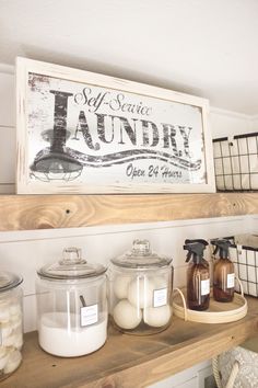 a shelf with jars, soaps and other items on it in front of a laundry sign