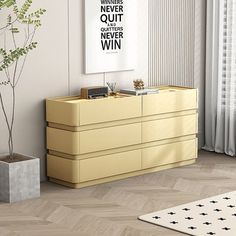 a living room with a yellow dresser next to a white rug and potted plant