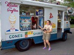 a woman standing in front of a food truck with ice cream cones on the side