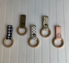 four wooden rings are hanging on the wall with different patterns and designs, one for each child's head