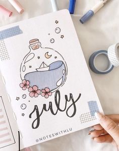 someone holding up a notebook with an image of a baby in a bathtub