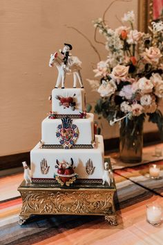 a three tiered wedding cake with figurines on top