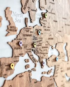 a wooden world map with pins on it