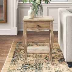 a small table with flowers on it in front of a couch