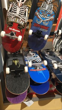 several skateboards are stacked on top of each other in a display case at a store