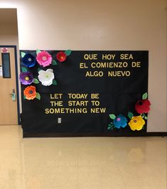 a bulletin board with flowers on it in a school hallway that reads, que hoy sea el commenzo de algo nuevo nevo let today be the start to something new