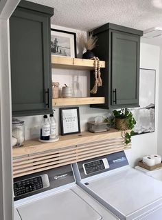 a washer and dryer in a laundry room with green cabinetry on the wall