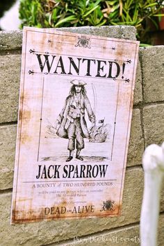 an old wanted poster on the side of a brick wall next to a white statue