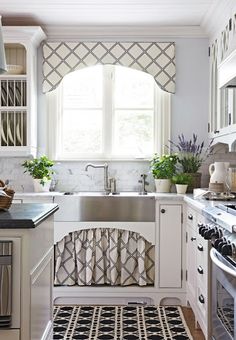 a kitchen with white cabinets and black and white patterned rugs on the counter top