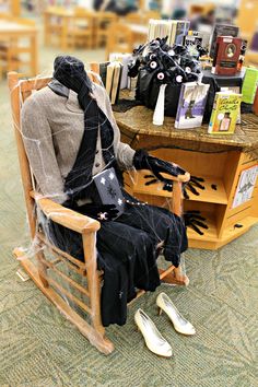 a person sitting on a rocking chair in front of a table with books and other items