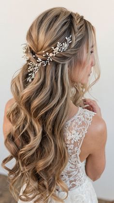 a woman with long blonde hair wearing a bridal hairstyle and flowers in her hair