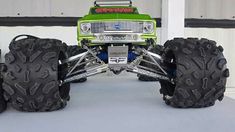 a green monster truck with four large tires on it's front wheel rims