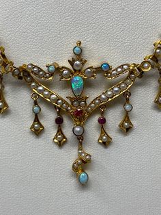 "Antique Art Nouveau 9Kt Opal, Ruby and Pearl Necklace. Approximate measurements: length of chain end to end 14 1/2\", center piece 70mm x 41mm. This 9Kt Opal, Ruby and Pearl necklace has been professionally appraised for $4500.00 and that written appraisal will accompany the necklace when sold. Since I am not an expert regarding this item, I have relied on the expertise of the certified professional appraisal. The following details about this Art Nouveau necklace are from a Certified Gemologist Art Nouveau Gemstone Necklaces For Formal Occasions, Art Nouveau Pearl Pendant Necklace For Wedding, Luxury Art Nouveau Formal Necklaces, Gold Art Nouveau Necklace With Intricate Design, Gold Art Nouveau Necklace With Gemstone, Art Nouveau Necklaces, Chocolate Color, Champagne Diamond, Opal Crystal