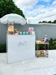 a small ice cream stand with an umbrella over it