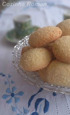 a glass bowl filled with cookies on top of a table next to a white cloth