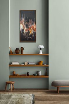 a living room with green walls and wooden shelves