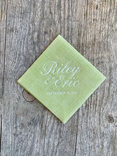 a green napkin with the word riley and co on it sitting on top of a wooden table