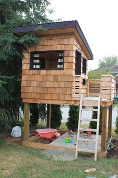 a small wooden house with a ladder to the roof