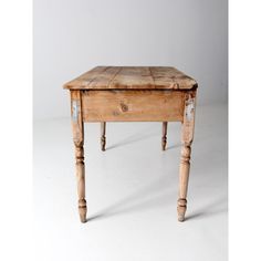 an old wooden table sitting on top of a white floor