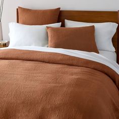 a bed with brown and white linens in a bedroom