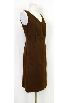 Sophisticated brown dress with a subtle pattern. Perfect for the office, style it with a blazer and pumps. You will be ready to hit the board room in style. Size 2 98% cotton, 2% elastane V-neck Back zipper Sleeveless Large front pockets Patterned fabric Lined Bust 34" Waist 30" Shoulder to hem 38.25" Brown V-neck Midi Dress For Work, Brown Cotton Midi Dress For Work, Fall Formal Cotton Midi Dress, Casual Fitted Business Dress, Fitted Casual Business Dress, Brown Fitted Knee-length Midi Dress, Brown Knee-length Midi Dress For Work, Office Brown Knee-length Midi Dress, Office Midi Dress Lined