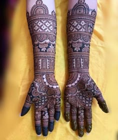 two hands with henna designs on them