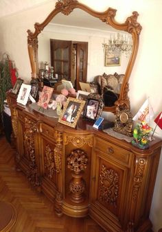 an ornate wooden dresser with pictures on it