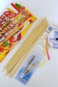 an assortment of food items including chopsticks, candy and cd on a white surface