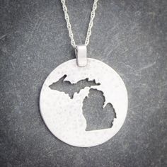 Flaunt your Michigan pride with this lovely sterling silver pendant.  Both peninsulas of Michigan are cut out of a large silver circle that has been textured to catch the light.This pendant measures approximately 1 1/8th inches in diameter, not including the bail.  Each pendant comes with a sterling silver chain at no extra charge. Please specify 16, 18, or 20 inches long for the chain.  If in doubt, 18 inch chains work well for most people. The pendant will come to you gift boxed, whether it is Etched Sterling Silver Round Disc Jewelry, Etched Sterling Silver Round Pendant Jewelry, Sterling Silver Coin Pendant Jewelry, Silver Circle, Metal Earrings, Metal Necklaces, Sterling Silver Chain, Sterling Silver Pendant, Sterling Silver Chains